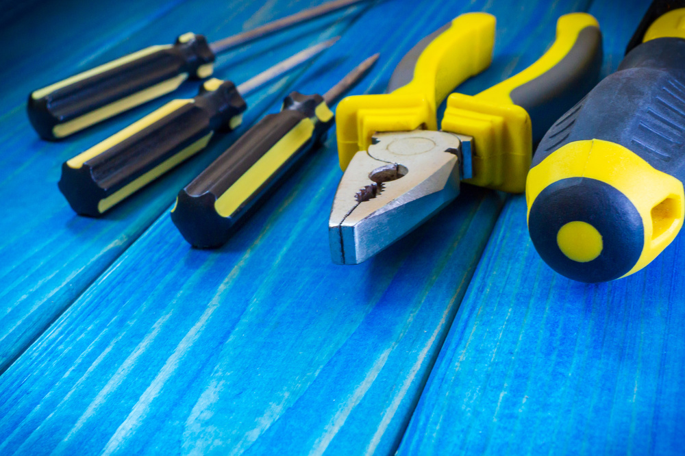 Hand tool on blue wooden background for home work or for locksmith.